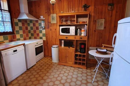 Il comprend une cuisine équipée d'une cuisinière, d'un four micro-ondes et d'une table. dans l'établissement Chalet privé au Mont-Serein ventoux, à Mont Serein