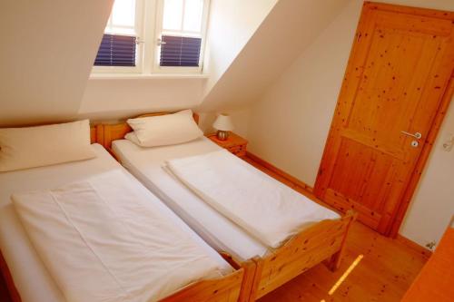 Habitación pequeña con 2 camas y ventana en Ambiente Ferienwohnungen, en Sankt Martin