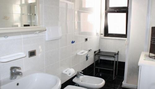 a white bathroom with a sink and a toilet at Trilocale Sissy sul mare in Gallipoli