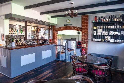 a bar with a table and chairs in a restaurant at The Old Castle Hotel in Rodwell