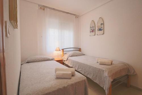 1 dormitorio con 2 camas y lámpara. en 053 - Altomar II 003 - comfortHOLIDAYS, en Gran Alacant