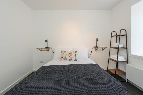 ein Schlafzimmer mit einem Bett mit einer schwarzen Decke in der Unterkunft Charming 3 Bed Village Green Cottage East Lothian in Gifford