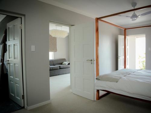 a bedroom with a canopy bed and a living room at Mogi Boutique Hotel in Ezulwini