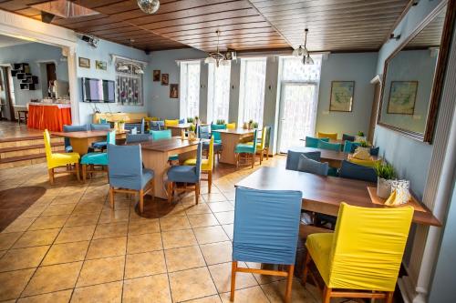 a restaurant with tables and colorful chairs in a room at Pokoje Gościnne Przemyk in Rewa