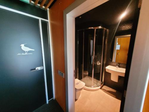 a bathroom with a toilet and a walk in shower at Urdaibai Bird Center in Gautegiz Arteaga