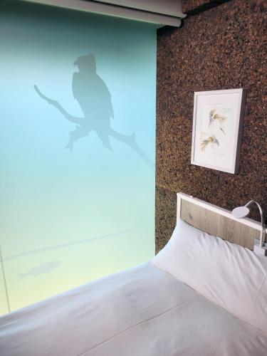 a bedroom with a bed and a wall with a picture at Urdaibai Bird Center in Gautegiz Arteaga