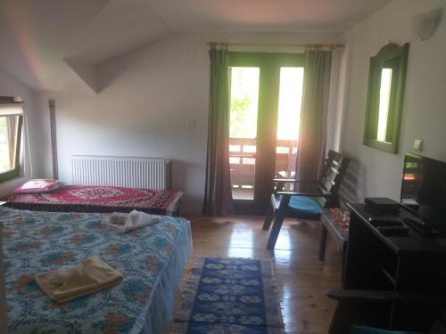 a bedroom with two beds and a table and a window at Pensiunea Carma in Certeju de Sus