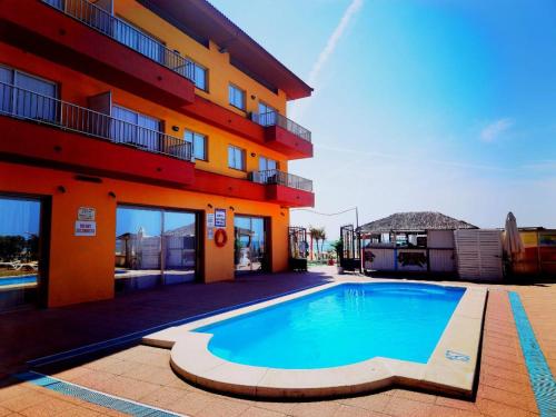 une piscine en face d'un bâtiment dans l'établissement Apartamentos Quintasol, à Malgrat de Mar