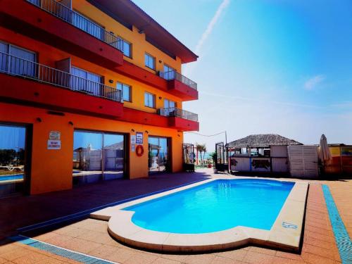 a swimming pool in front of a building at Apartamentos Quintasol in Malgrat de Mar
