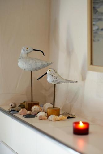two birds on display on a counter with a candle at Ferienhaus Eifel 1851 in Gipperath