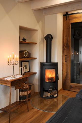 a fireplace in a living room with a table and candles at Ferienhaus Eifel 1851 in Gipperath