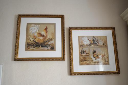 two framed pictures of chickens on a wall at Ferienhaus Eifel 1851 in Gipperath