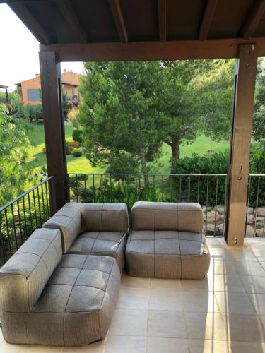 a couch sitting on a screened in porch with a view at Casa bonmont con vistas al mar piscina y port aventura in Cambrils