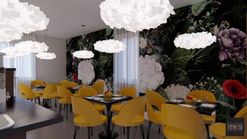 een restaurant met gele stoelen en bloemen aan de muur bij 4essences Boutique Rooms in Maratea