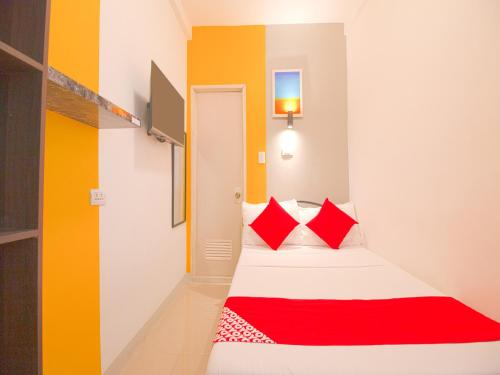 a bedroom with a bed with red pillows at Barrio House Mactan in Mactan