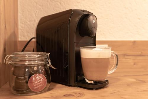 una macchina per il caffè nero accanto a un bicchiere di birra di Senner Appartements a Umhausen