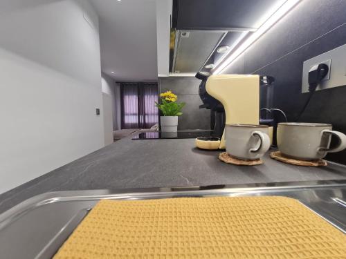 a kitchen counter with two cups and a yellow rug at LoftinMalaga in Málaga