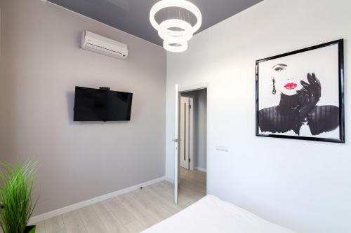 a living room with white walls and a flat screen tv at LEOGRAND VIP Apartments on Pidhirna 3 in Lviv