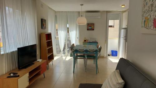 a living room with a table and a television at Apartamento céntrico cerca de la playa in L'Ametlla de Mar