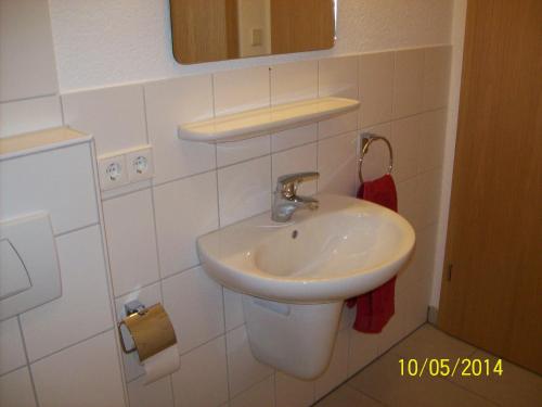 a white bathroom with a sink and a mirror at Ferienwohnung Lamm in Göppingen