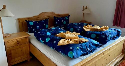 a bedroom with two beds with blue comforters at Haus Wieck auf dem Darß in Wieck