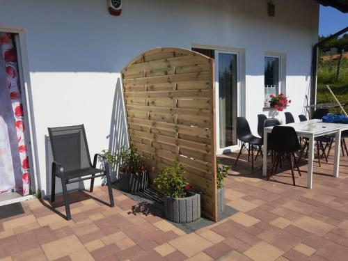 pared de madera en un patio con sillas y mesa en Mazurskie Wytchnienie, en Giżycko