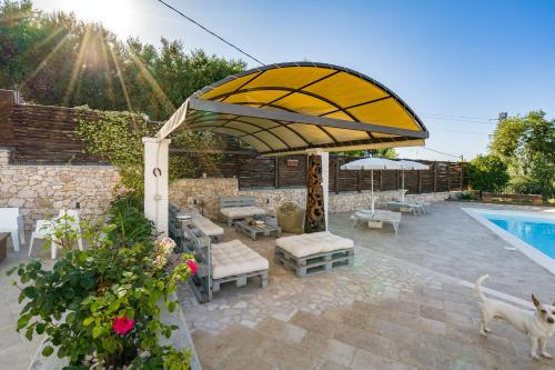 a patio with an umbrella and a swimming pool at Borgo Canneto in Rodi Garganico