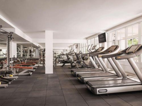 a gym with rows of treadmills and machines at Raffles Hotel Le Royal in Phnom Penh