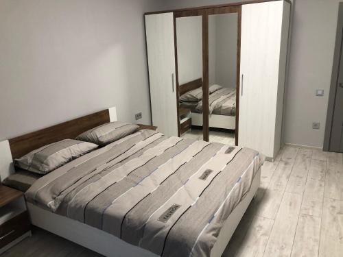 ein Schlafzimmer mit einem großen Bett und einem Spiegel in der Unterkunft GIL Apartments, Volodimirskaja 90.246 - Majetok Bozdosh in Uschhorod