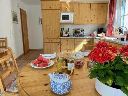 a kitchen with a wooden table with flowers on it at Haus Wieck auf dem Darß in Wieck