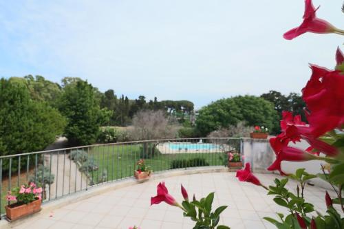 a balcony with red flowers and a swimming pool at Relais Delle Rose in Lecce