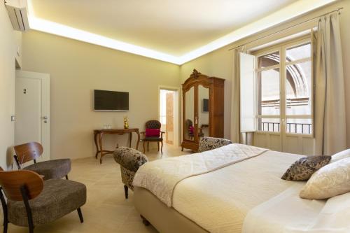 sypialnia z łóżkiem, stołem i krzesłami w obiekcie Maecò Ortigia B&B w Syrakuzach
