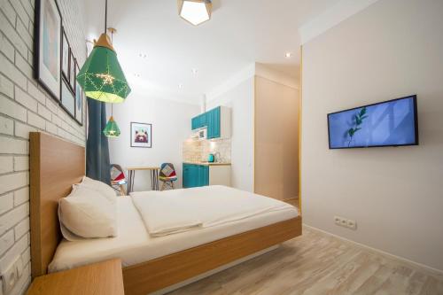 a bedroom with a bed and a tv on a wall at Idea Design Apart-Hotel in Kyiv