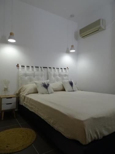 una camera da letto con un grande letto bianco con due cuscini di D&D apartments ad Antica Epidauro