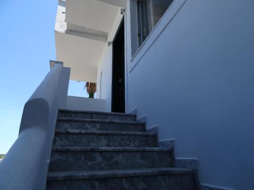 a staircase leading up to a white house at D&D apartments in Ancient Epidavros