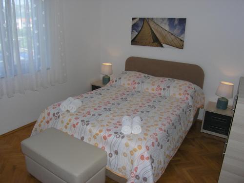 a bedroom with a bed with shoes on it at Apartments JADRANKA with magnificent views of the sea - Baska in Baška