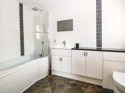 une salle de bains avec baignoire, lavabo et toilettes dans l'établissement Keepers Cottage, à Beeston