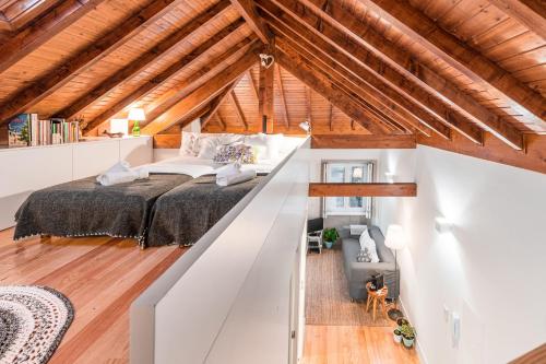 ポルトにあるHome in Porto - Cozy 2BR Duplex by LovelyStayのベッドルーム1室(屋根裏部屋に大型ベッド1台付)