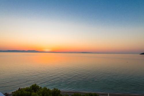 a sunset over a large body of water at Paraskevas Boutique Hotel in Tiros
