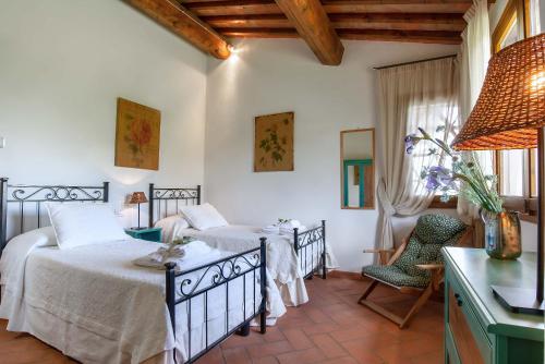 a bedroom with two beds and a table and chairs at Villa Lionella Country Resort in Montaione