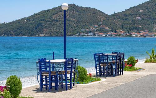 two blue chairs and a table next to the water at Paraskevas Boutique Hotel in Tiros