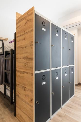 a row of lockers in a room with a bed at Four Rooms Hostel in Lugo