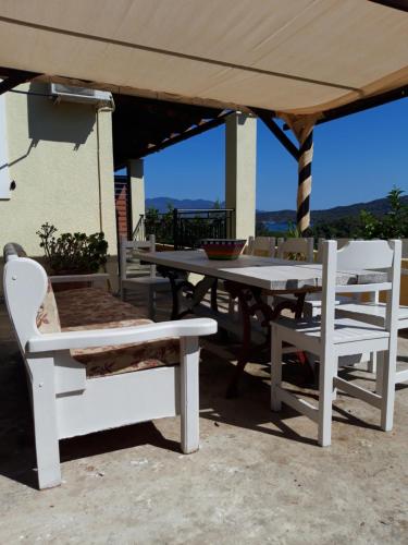 a table and chairs under an umbrella on a patio at Elaia country living in Galatas