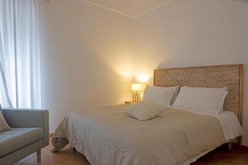 ein Schlafzimmer mit einem Bett, einem Stuhl und einer Lampe in der Unterkunft Due Passi in Capri