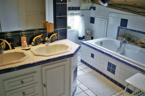 a bathroom with two sinks and a bath tub at Terre d'espérance in Saint-Aignan