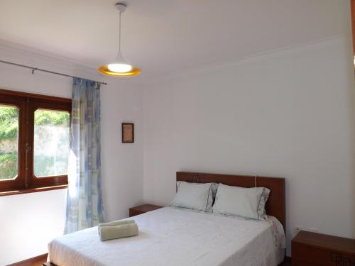 a bedroom with a bed and a window at Casa Oliveira in Grovelas