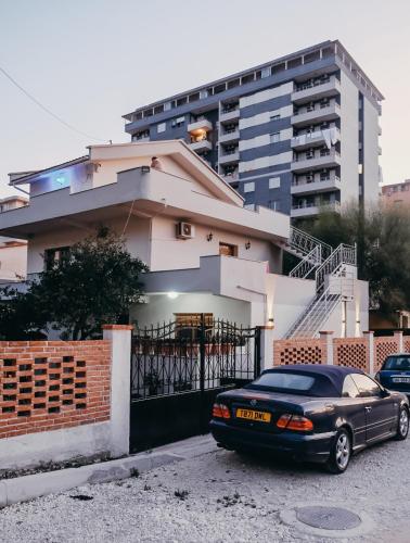 una macchina nera parcheggiata di fronte a una casa di Apartments Mehmeti a Vlorë
