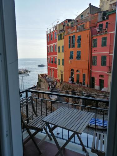 a view of the ocean from a balcony with a bench at Life Class Apartment in Riomaggiore