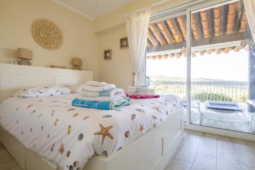 - une chambre avec un lit, des serviettes et une fenêtre dans l'établissement La Maison de Laurence, aux Issambres