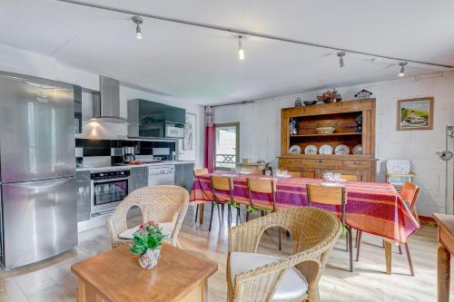 une cuisine avec une table et des chaises dans une cuisine dans l'établissement Alpage, à Saint-Nicolas-la-Chapelle